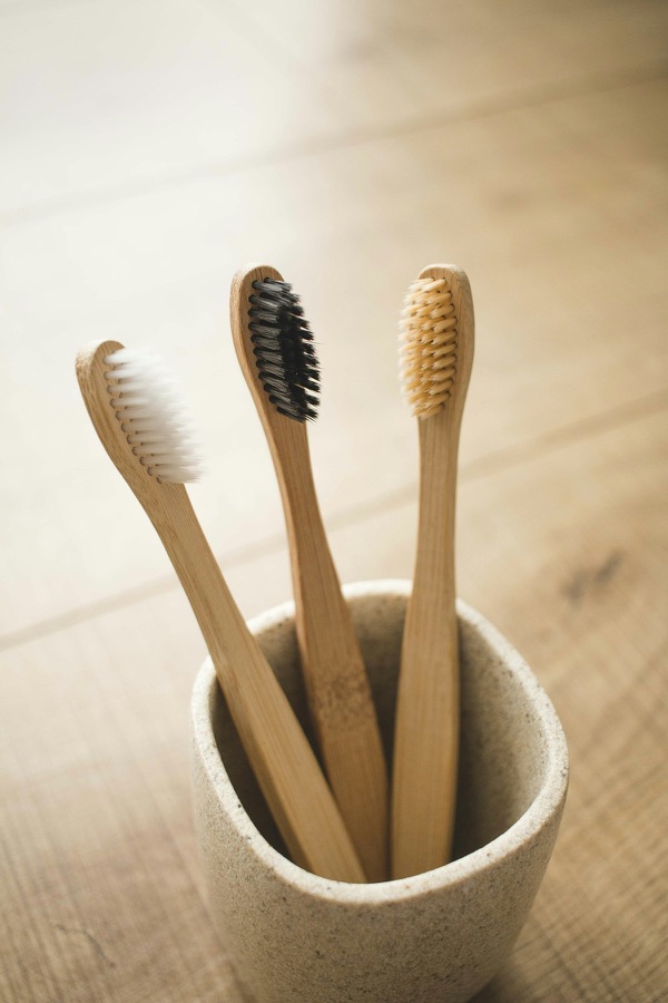 Bamboo-handled toothbrushes in a ceramic holder