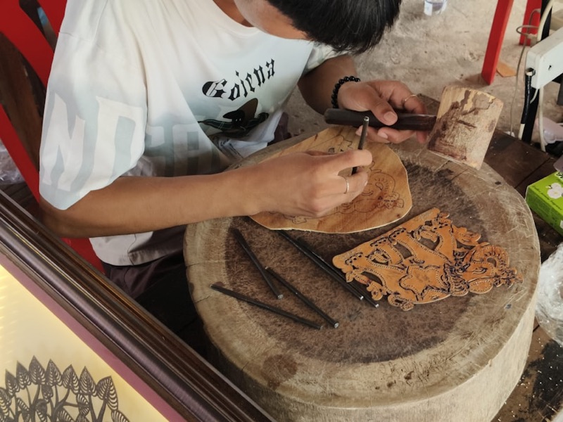 A craftsperson working a mark into a wooden surface